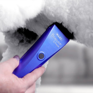 Blue Wahl Bravura Lithium hair trimmer being used on a fluffy white dog.