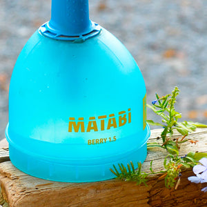 Blue Matabi berry 1.5 device on a wooden surface with plants in the background