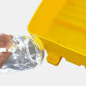 Clear bottle being poured into a yellow egg incubator with a white background
