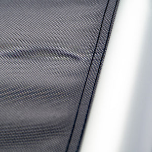 Close-up of a textured black fabric surface with a white background