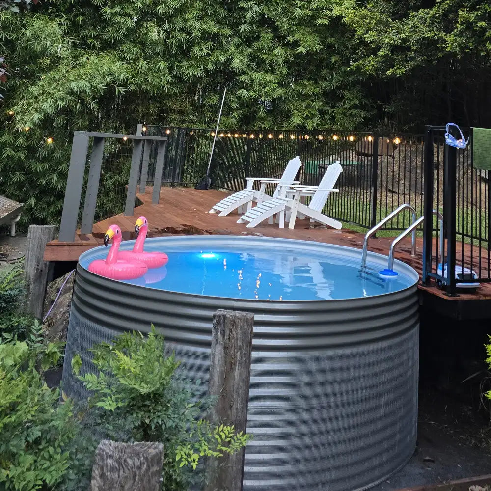 Small above-ground pool with pink flamingo floaties in a backyard setting.