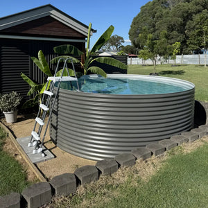 Large metal above-ground pool with a ladder in a backyard setting