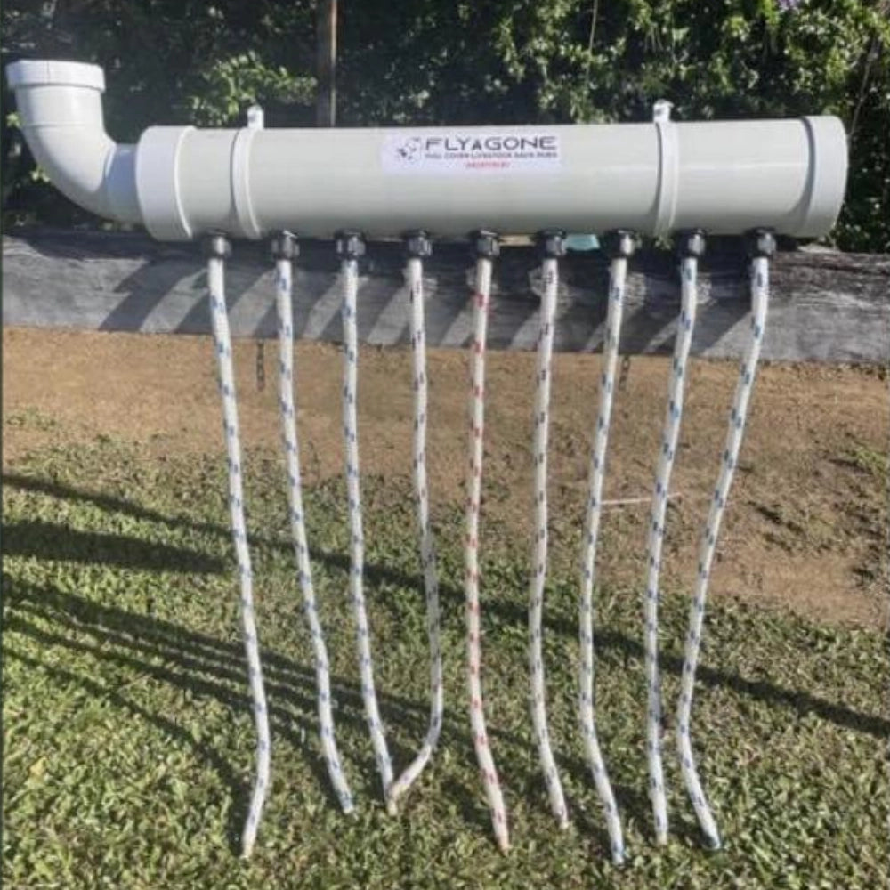 White cattle pest control device with multiple wicks on a grassy area