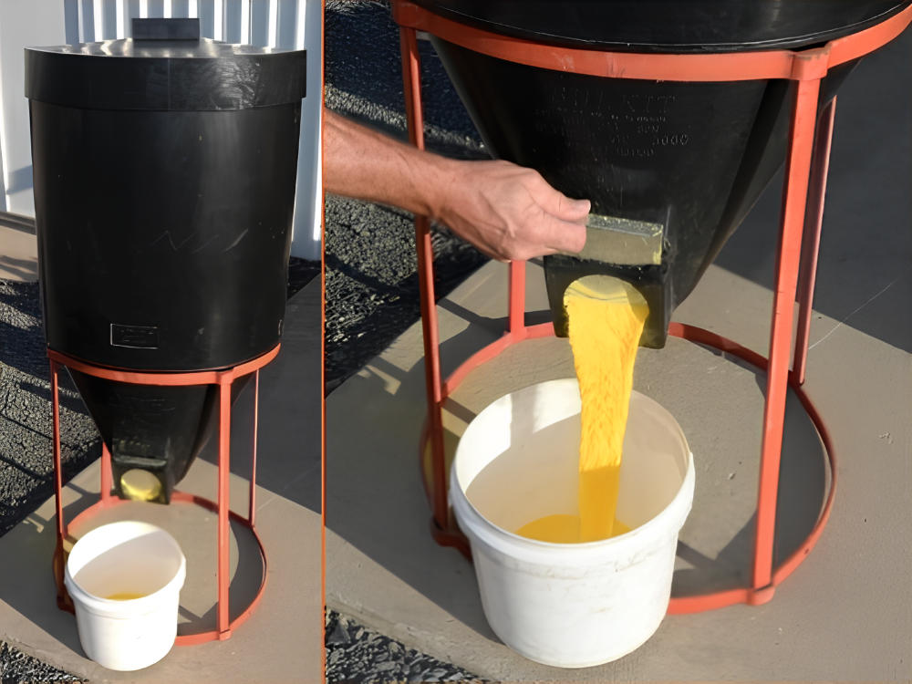 Black mini silo being used to transfer yellow grain into a white bucket.