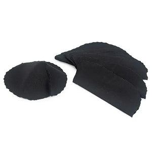 A stack of black livestock pink-eye patches on a white background