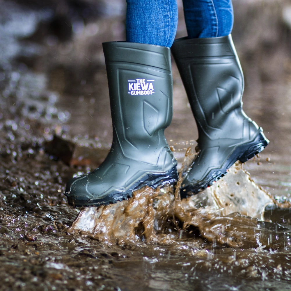 Person wearing green rubber boots with 'The Kiewa Company' logo walking through water.