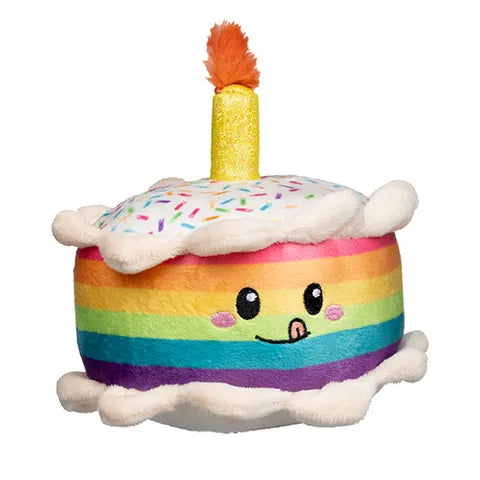 Plush toy shaped like a rainbow birthday cake with a candle on a white background