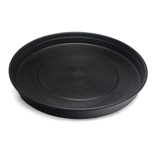 Black round chicken feeding tray with textured surface on a white background